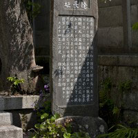 海に近い森に佇む甘縄神明神社の境内にある、安達盛長邸跡の石碑。