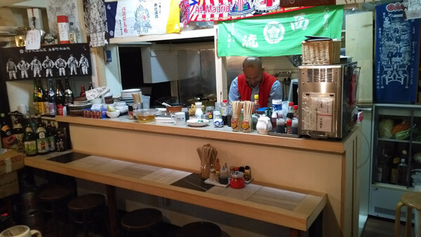 袈裟丸家の店内。十坪程の店にはカウンター5席とテーブルが1つ。